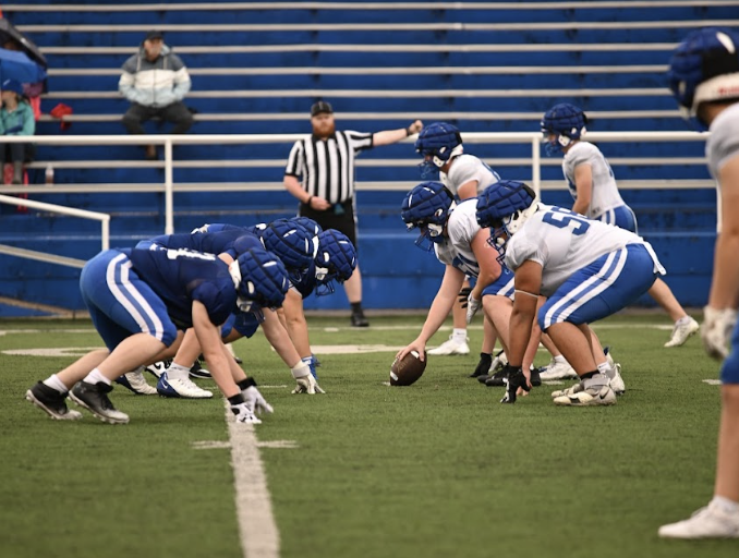 The offensive and defensive linemen set up on the line of scrimmage. 